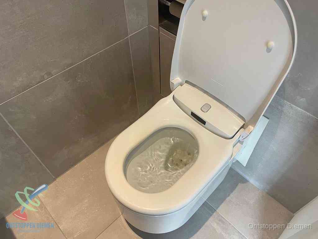 Een toiletpot vol troebel water met drijvend papier en restanten, de meest voorkomende oorzaak van een verstopte wc in Diemen