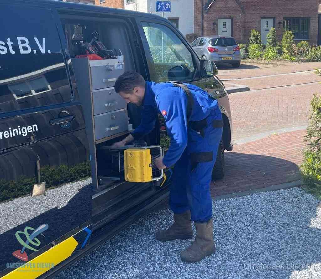 Een monteur pakt apparatuur uit de bedrijfsbus voor service aan huis, het moment om een professional in te schakelen voor een verstopte wc in Diemen