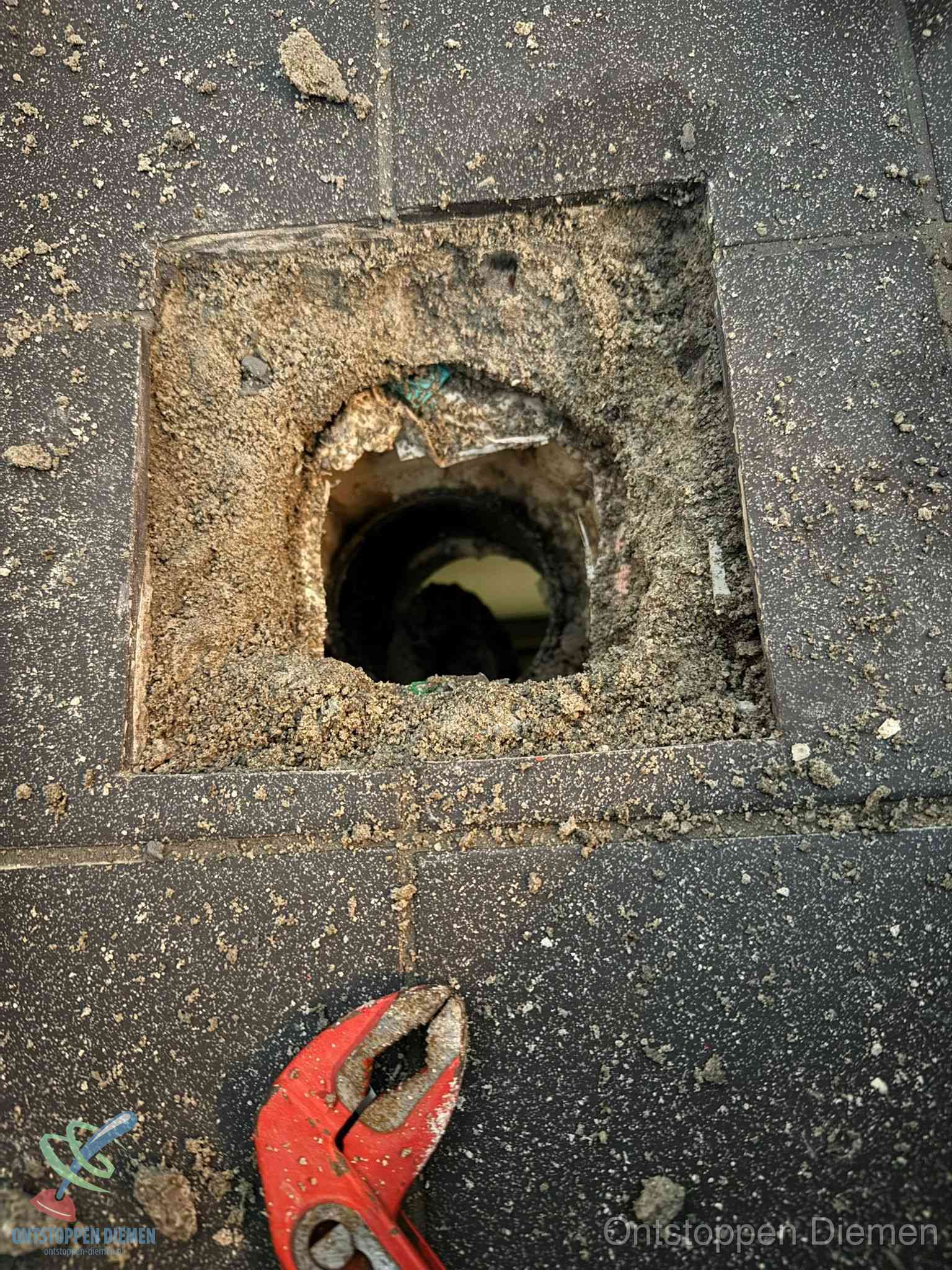 Geopend rioolputje op de erfgrens dat laat zien wie eigenaar is van de riolering in Diemen
