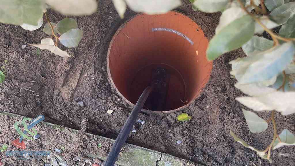 Open inspectieput in de tuin waar een veer rioolvliegjes en stankoverlast aanpakt in Diemen