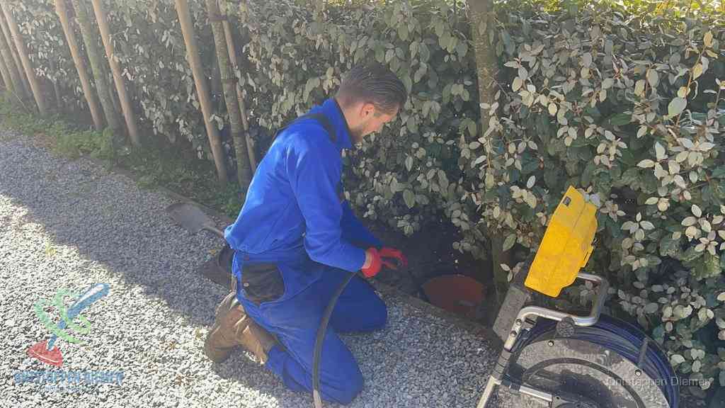 Monteur aan het werk bij een rioolput, de werkwijze voor riool ontstoppen in Diemen
