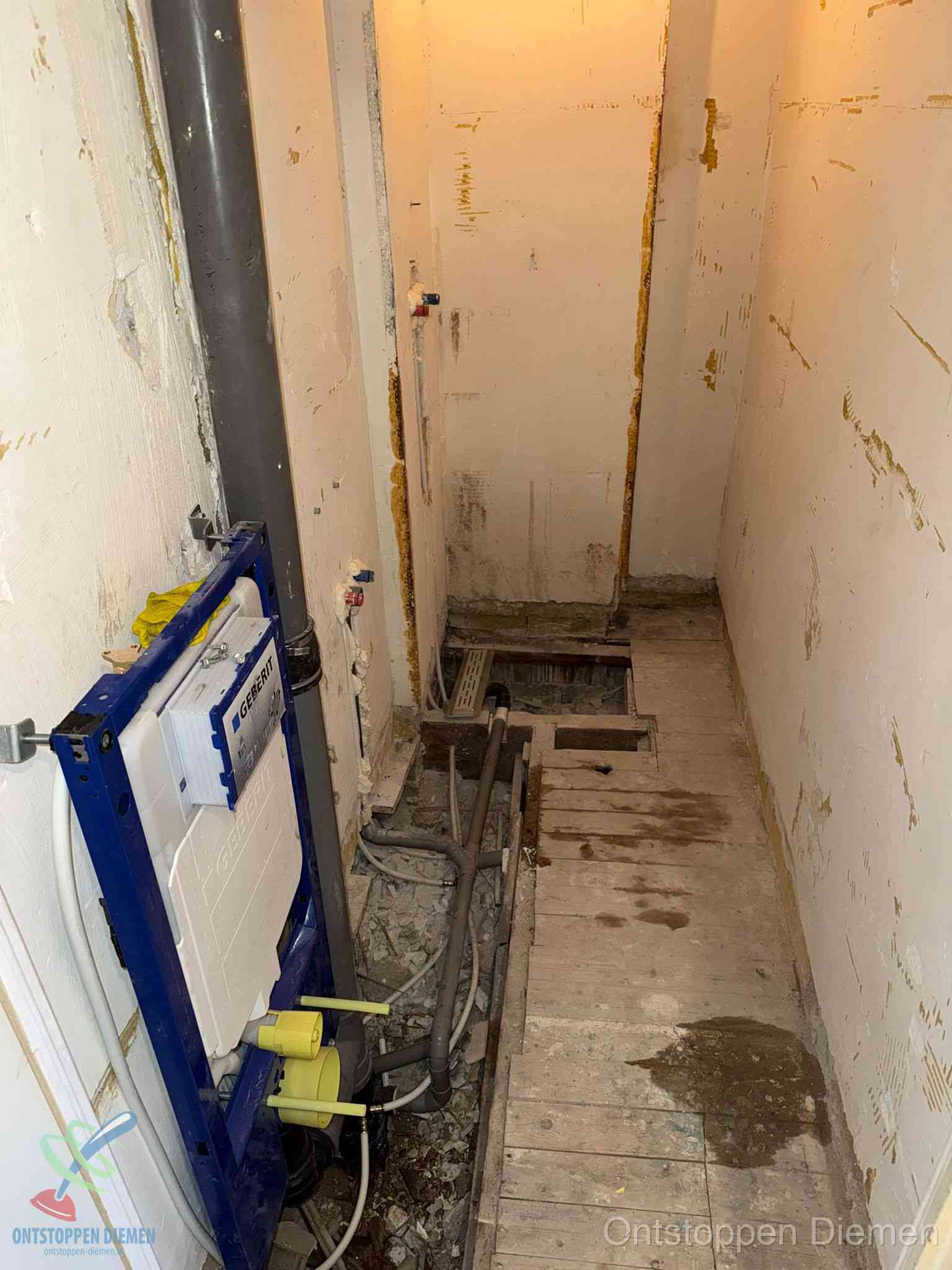 Een opgebroken toiletruimte tijdens renovatie met een Geberit inbouwreservoir en blootliggende oude afvoerleidingen, typisch voor oudere woningen in Diemen